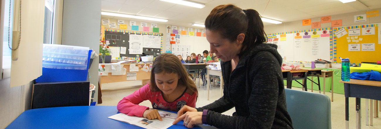 Photo of a volunteer parent reading to a student